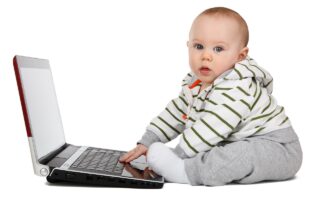 Ein Baby, das auf einen Laptop tippt.